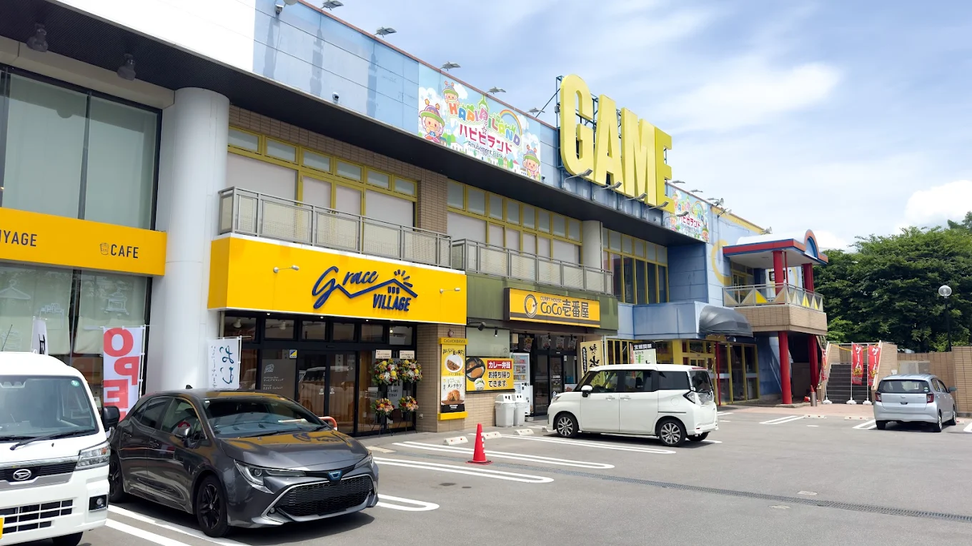 佐久ステーションパークの建物外観。黄色いgrace VILLAGEの看板と大きなGAMEの文字が目印。